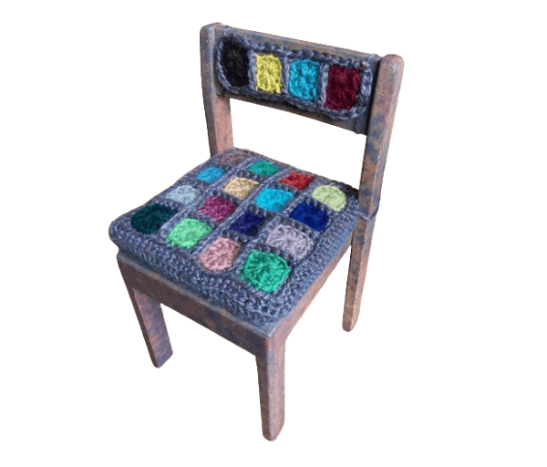 .Houten stoeltje met dik vierkant gehaakt kussen